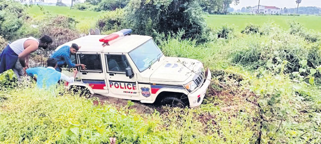 పొలాల్లోకి దూసుకెళ్లిన పోలీస్‌ వాహనం