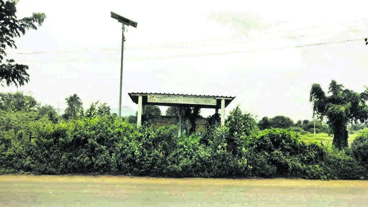 BUS: బస్‌ షెల్టర్‌ను కప్పేసిన ముళ్ల పొదలు