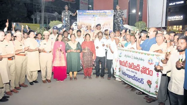 కొవ్వొత్తులతో ర్యాలీ నిర్వహిస్తున్న పోలీసులు