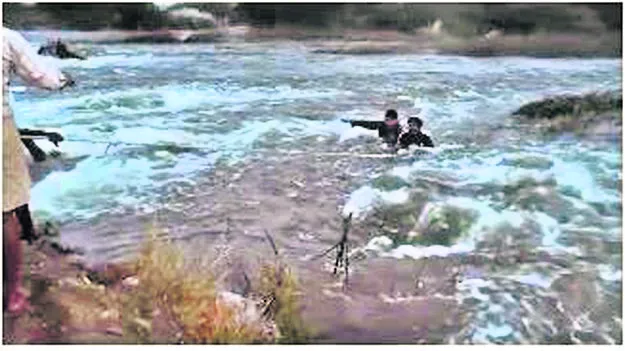 నదిలో చిక్కుకున్న యువకులు