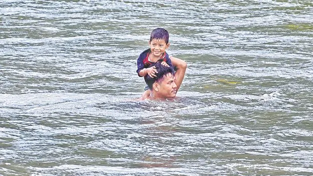 ప్రాణాలకు తెగించి.. బాలుడిని గెడ్డ దాటించి