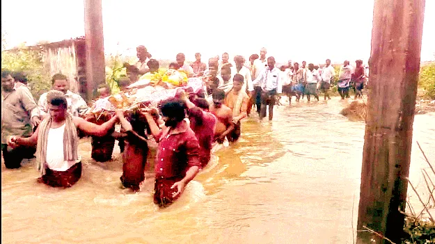 To the funeral, in waist-deep water... నడుంలోతులో అంత్యక్రియలకు..