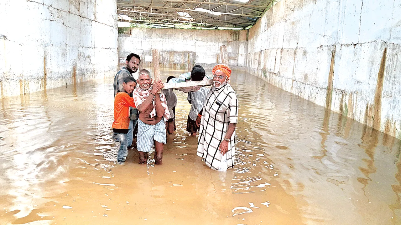 మంచంపై మోసుకుంటూ.. వరద నీటిని దాటించి